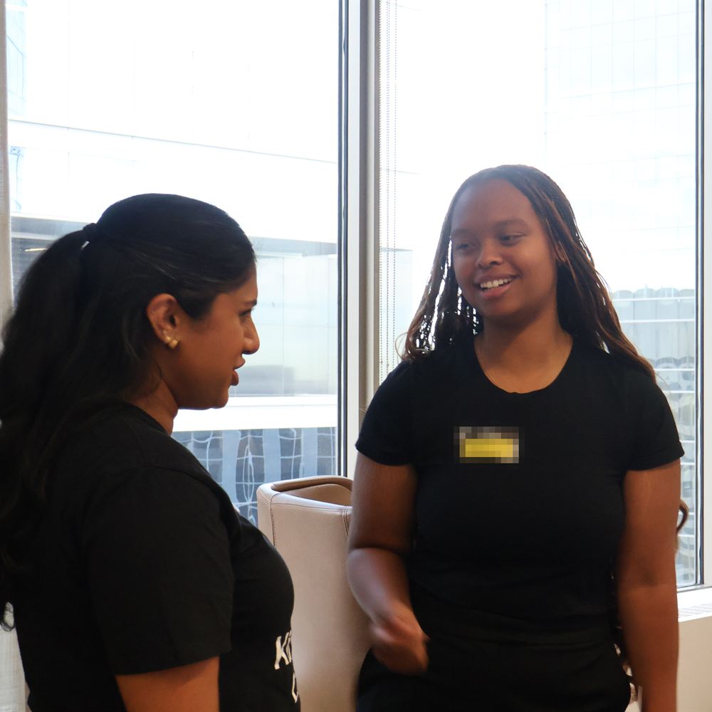 Two people chatting at a past Network event, one wearing a Network name tag.